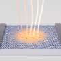 Faint far-infrared radiation drives a correlated insulator-to-metal transition in magic-angle graphene